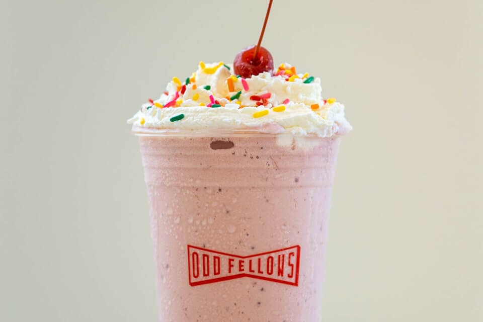 Strawberry milkshake with whipped cream and rainbow sprinkles